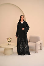 Black abaya seated view — sheer geometric hem with Dori detail Al Anood